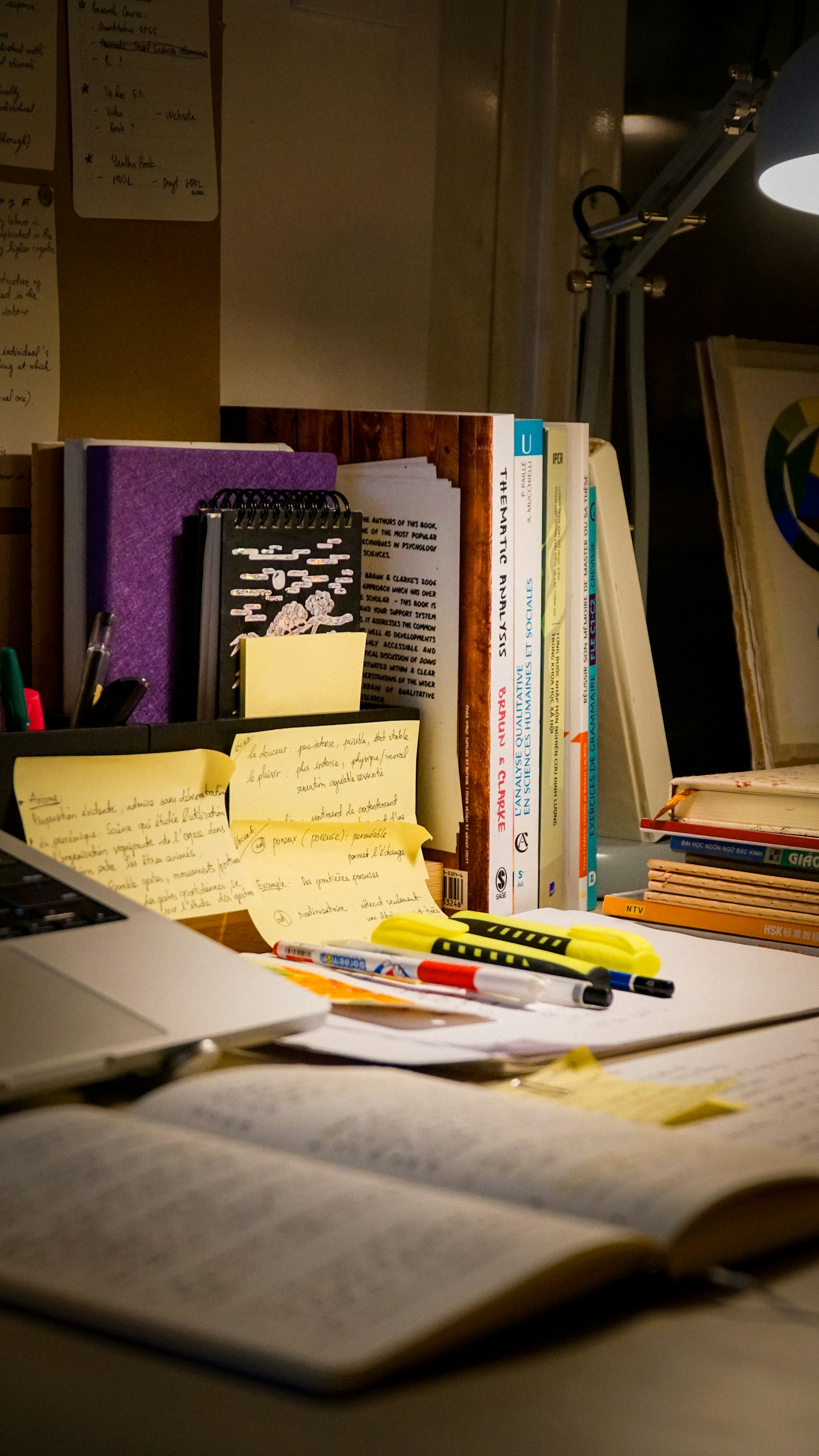 Research books, notes, and study materials arranged on a working desk
