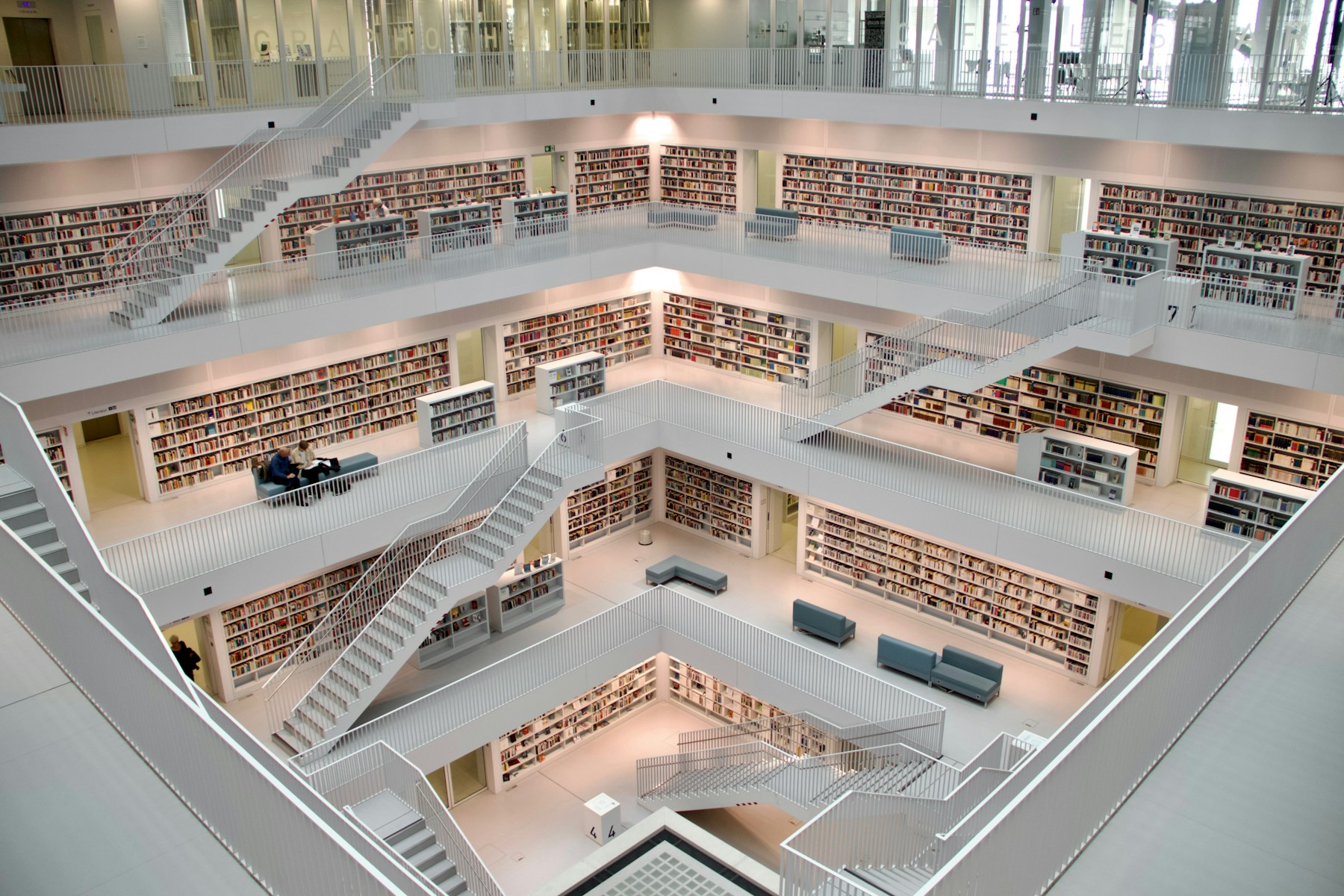 Multi-level modern library with bookshelves and intersecting stairways